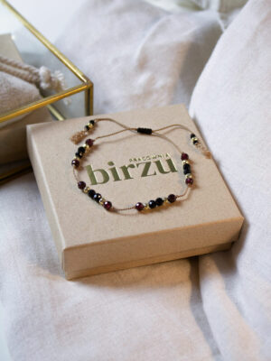 Bransoletka na nici jedwabnej z czarnych turmalinów i granatów ułożona na ozdobnym pudełku